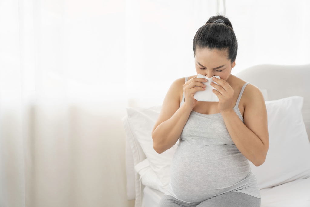 Простуженная женщина на большом сроке беременности